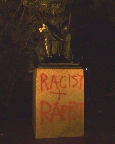 Statue of Thomas Jefferson vandalized with the words "Racist + Rapist" spray painted on it